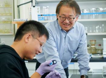 教授のサポートを受けながら実験する学生