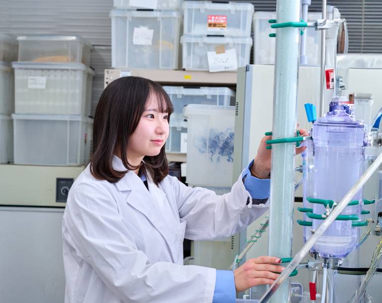 白衣を着て実験に取り組む学生