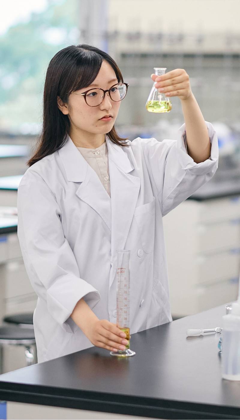 白衣を着て実験に取り組む学生